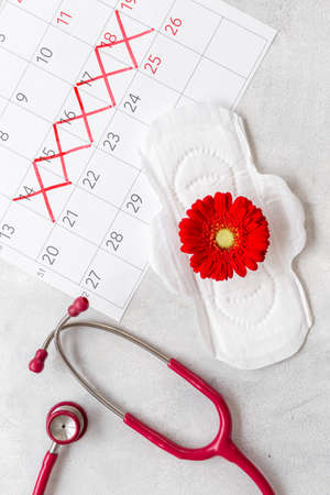 Women health. Stethoscope and calendar with red days of menstruation periodの写真素材