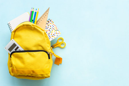 Yellow school backpack with student accessories. College and school concept