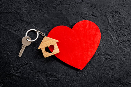 Wooden house shaped keychain with keys. Real estate conceptの写真素材