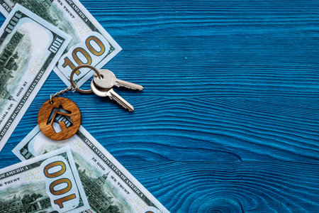 Saving money concept with house shaped keychain and money cashの写真素材