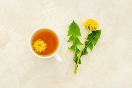 Cup of healing herbal tea with yellow dandelions flowersの写真素材