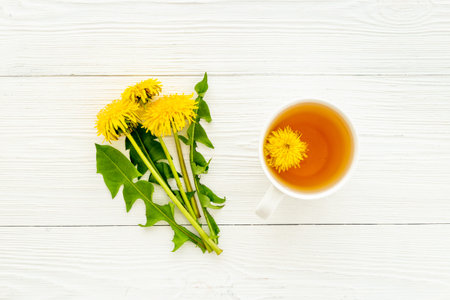 Herbal tea with meadow healing herbs - yellow dandelions blossoms and leavesの写真素材