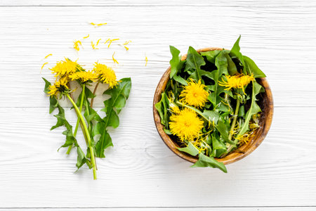Meadow healing herbs - yellow dandelions blossoms and leaves in bowlの写真素材