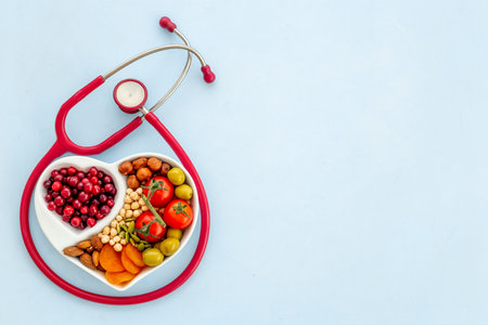 Cholesterol diet concept. Healthy food in heart shaped dish with stethoscopeの写真素材