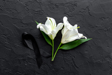 White liles flowers and black ribbon as symbol of the funeral. Mourning conceptの写真素材