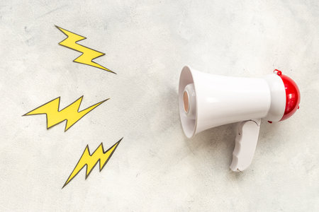 Attention and hot news concept. Megaphone with flying lightningの写真素材