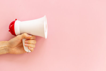Attention concept. Hand holding megaphone for announcing hot news or advertisingの写真素材