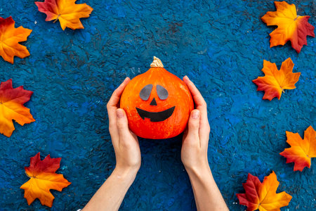 Flat lay of orange Halloween pumpkins and dry leaves, top viewの写真素材