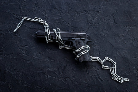 Hand gun weapon in chains. Ban on carrying weapons gun law conceptの写真素材