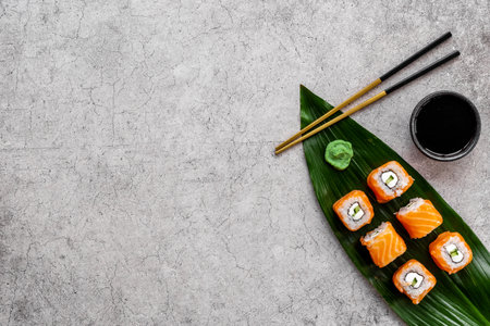 Sushi roll set with chopsticks on green Bamboo leave, top viewの写真素材