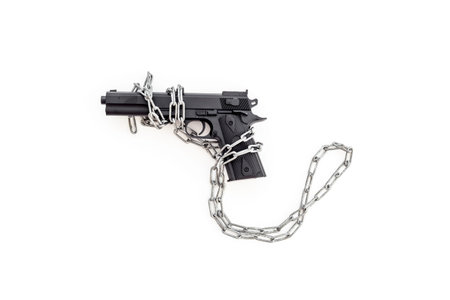 Hand gun weapon in chains - illegal use of weapons concept