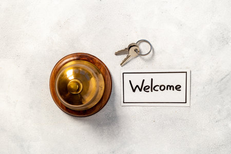 Hotel service bell on reception desk with welcome word on paperの写真素材