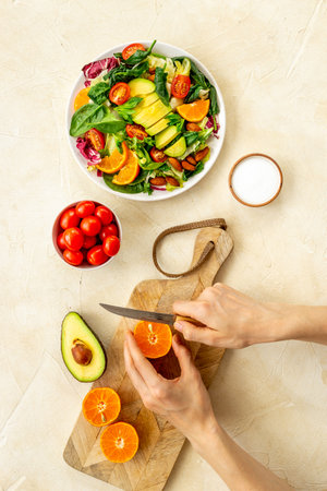 Hands cooking vegetarian salad with avocado and tomatoesの写真素材