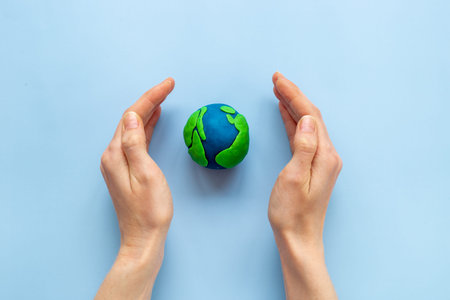 Modeling clay world in hands. Earth Day concept