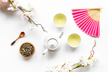 Flat lat of Asian tea set with teapot and cherry blossom branch, top viewの写真素材