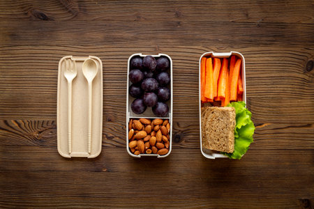 Food in lunch boxes with bamboo cutlery, top view