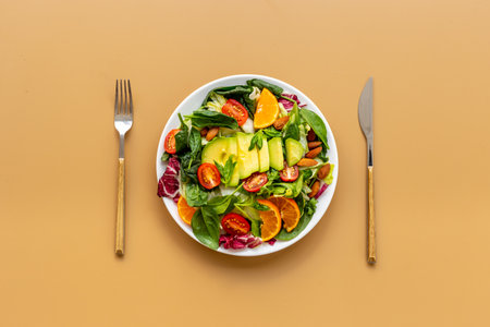 Fresh green salad with avocado and tomatoes, top view