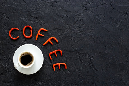 White cup of hot black coffee with rubber letters. Coffee break conceptの写真素材