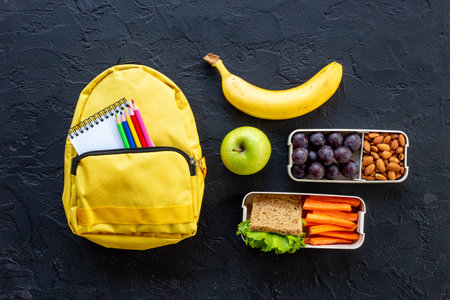 Healthy school lunch box with fruits and backpack, top viewの写真素材