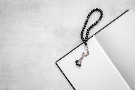 Koran book and black Muslim rosary with silver crescent moonの写真素材