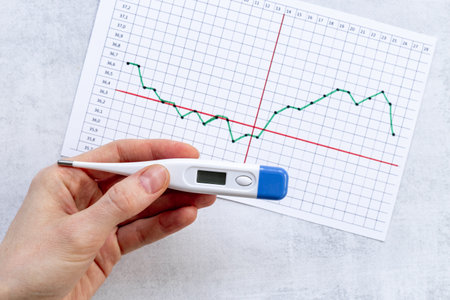 Female period ovulation temperature calendar with with thermometer for pregnancy planning.