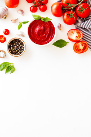 Tomato sauce passata in bowl with fresh tomatoes and basil.
