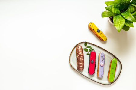 Many various glazed eclairs with chocolate and berry. Sweet food background.