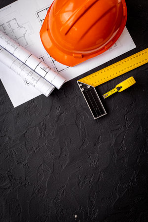 House drawing blueprints with helmet for architectural project, construction engineering.