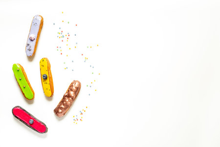 Pattern of various glazed eclairs cakes. Sweet food background.