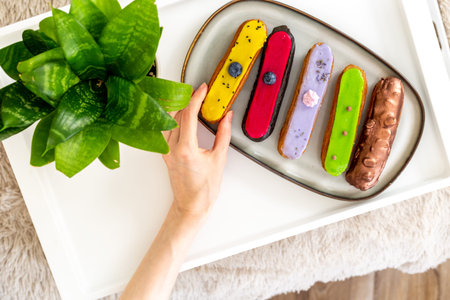 Many eclairs with different flavors. Sweet food background.