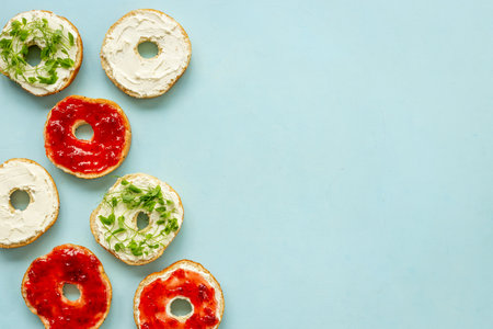 Fresh baked bagels with berry jam and cheese cream. Homemade bread background.の写真素材