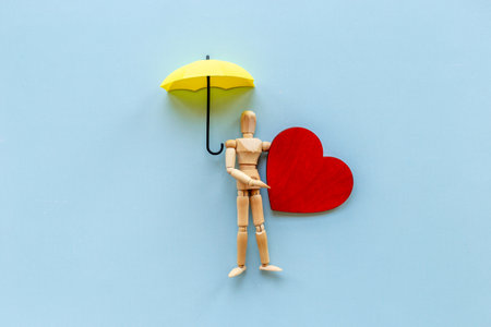 Wooden figure of a man with heart. Heart diseases and medical treatment concept.の写真素材