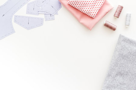 Tailors workplace with sewing patterns and cotton dress fabric, top view.の写真素材