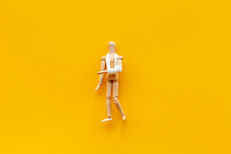 Wooden dummy man with broken arm - arm in bandage.の写真素材