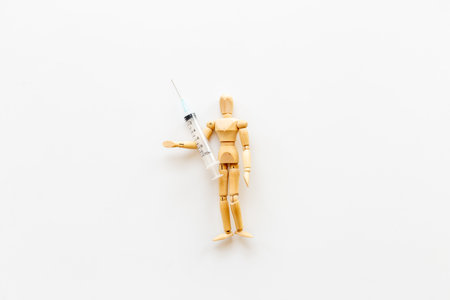 Wooden figurine of a man with syringe and vaccine.の写真素材