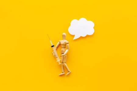 Wooden figurine of a man with syringe and vaccine. Medicine and healthcare concept.の写真素材