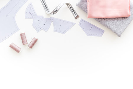 Tailors workplace with sewing patterns and cotton dress fabric, top view.の写真素材