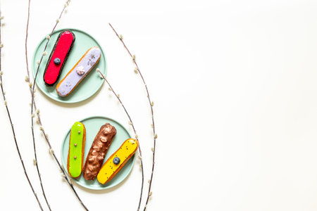Set of various glazed eclairs with chocolate and berry, top view.