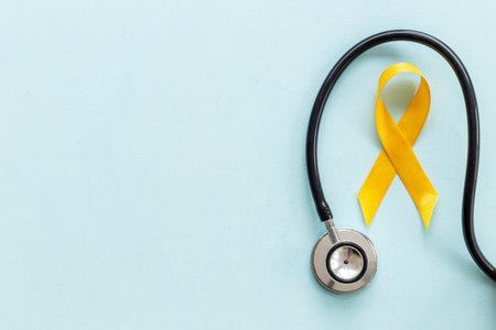 Yellow ribbon symbol of bone cancer and suicide problems awareness concept.の写真素材