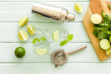 Alcoholic drink mojito making in blender with mint and lime, top view.