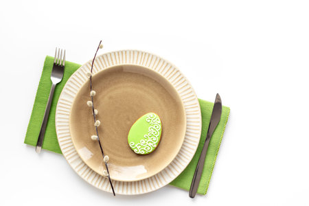 Festive table setting for Easter dinner with a spring willow sprig.