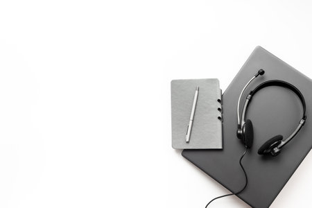 Office desk with VOIP headset and laptop computer. Call center operator desktop, top viewの写真素材