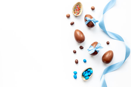 Easter festive background. Chocolate Easter eggs in blue ribbon with sweets.の写真素材