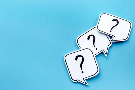 Question marks on paper speech bubbles. FAQ concept or search information concept.