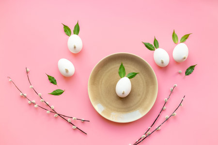 Easter background. Eggs in the shape of bunnies made of spring leaves and willow bud, with willow...