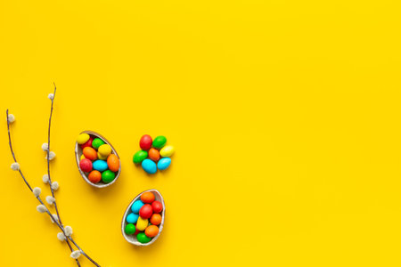 Happy Easter background with chocolate eggs and spring branch, top view.