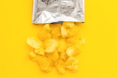 Pack of splashing crispy potato chips, top view. Fast food and snack background.の写真素材