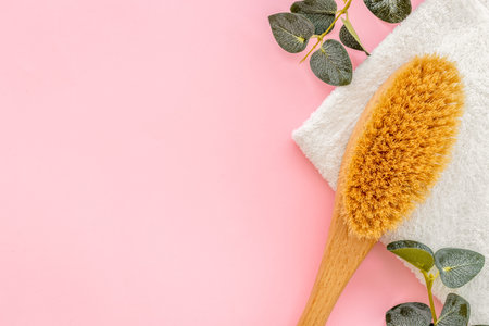 Spa massage body brush and green leaf. Bath background.
