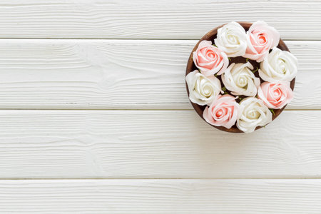 Flowers buds in wooden bowl, roses top view.の写真素材
