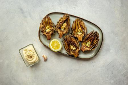 Roasted artichokes with olive oil and garlic. Cooked vegetables, top view.の写真素材